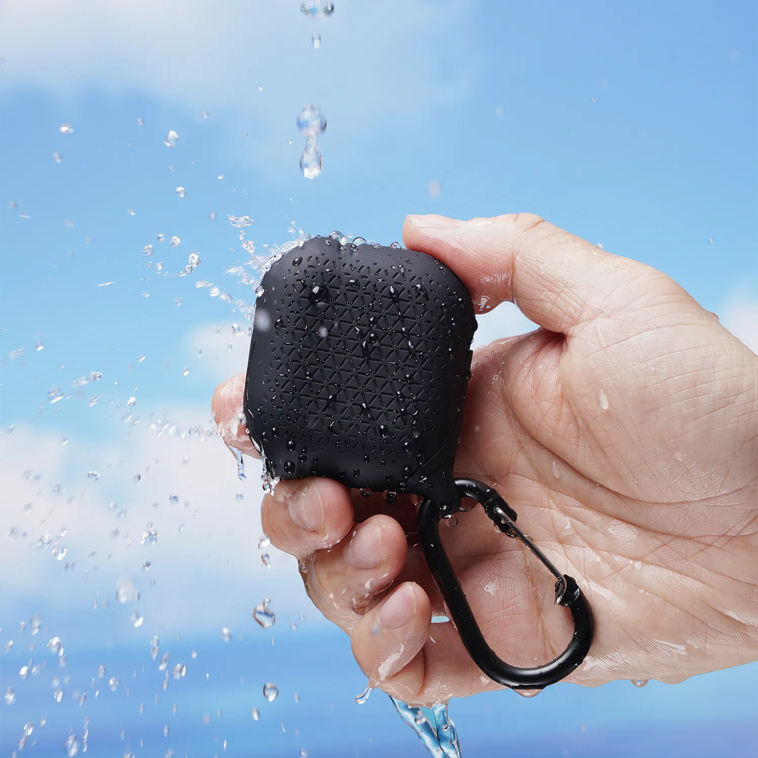 A hand holds Catalyst Case US's AirPods (Gen 3) Waterproof Case with carabiner, splashed by water against a bright blue sky, highlighting the case’s rugged protection and waterproof durability.