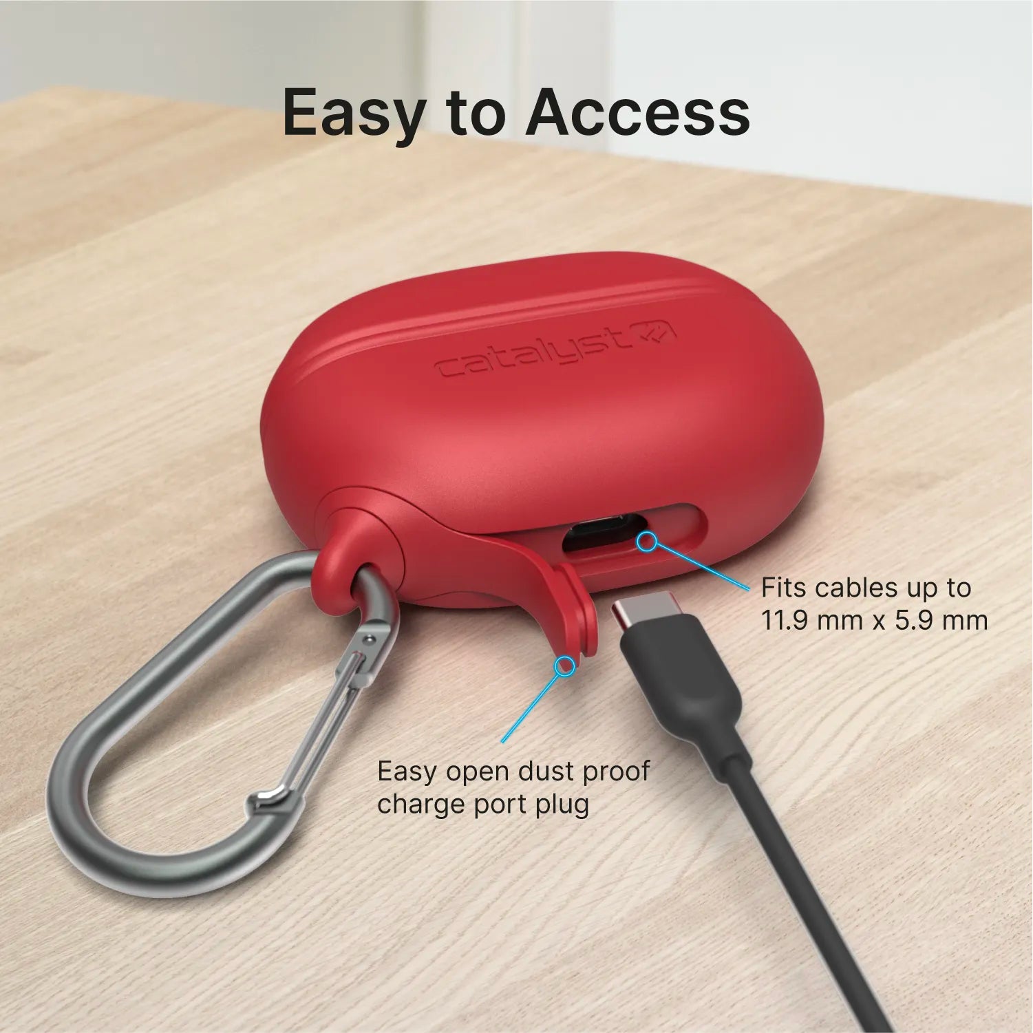 A red Catalyst Case US waterproof case with carabiner for Beats Studio Buds/Studio Buds Plus sits on a wooden surface. A black charging cable is plugged in, highlighting the dustproof plug, cable compatibility, and MIL-STD-810G drop protection.