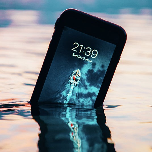 The Catalyst Case US iPhone 15 Pro Max - Waterproof Case offers total protection, keeping your phone fully functional even when wet—perfect for use around water, as shown by a submerged device displaying the time and a pool scene on its screen.