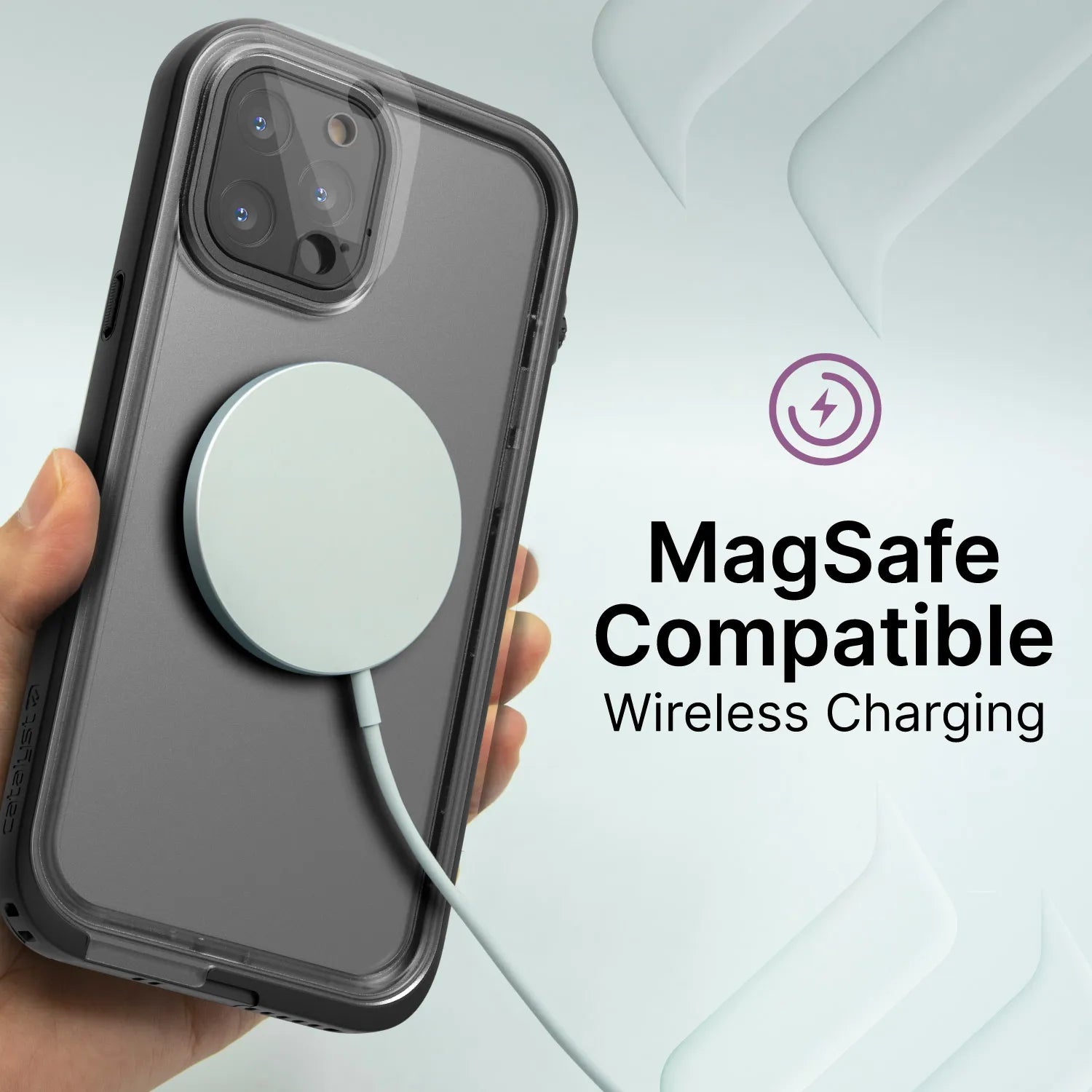 A hand holds an iPhone 12 Pro in a Catalyst Case US Waterproof Case, Total Protection, with a round MagSafe wireless charger attached. “MagSafe Compatible Wireless Charging” is shown beside the phone, under a purple charging symbol on a light background.