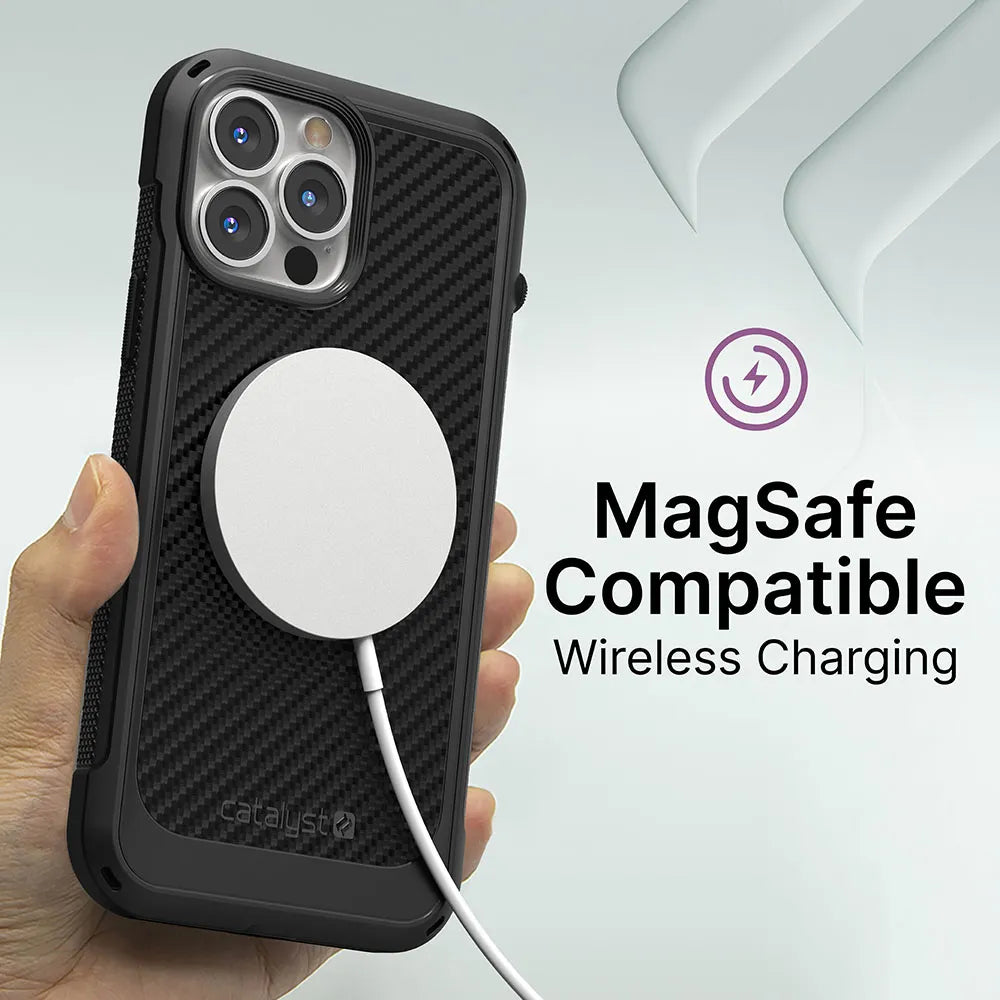 A hand holds an iPhone 13 Pro Max in the Catalyst Case US Vibe Case (MagSafe Compatible) with a wireless charger attached. The text says “MagSafe Compatible Wireless Charging” and there’s a purple wireless charging icon beside it.