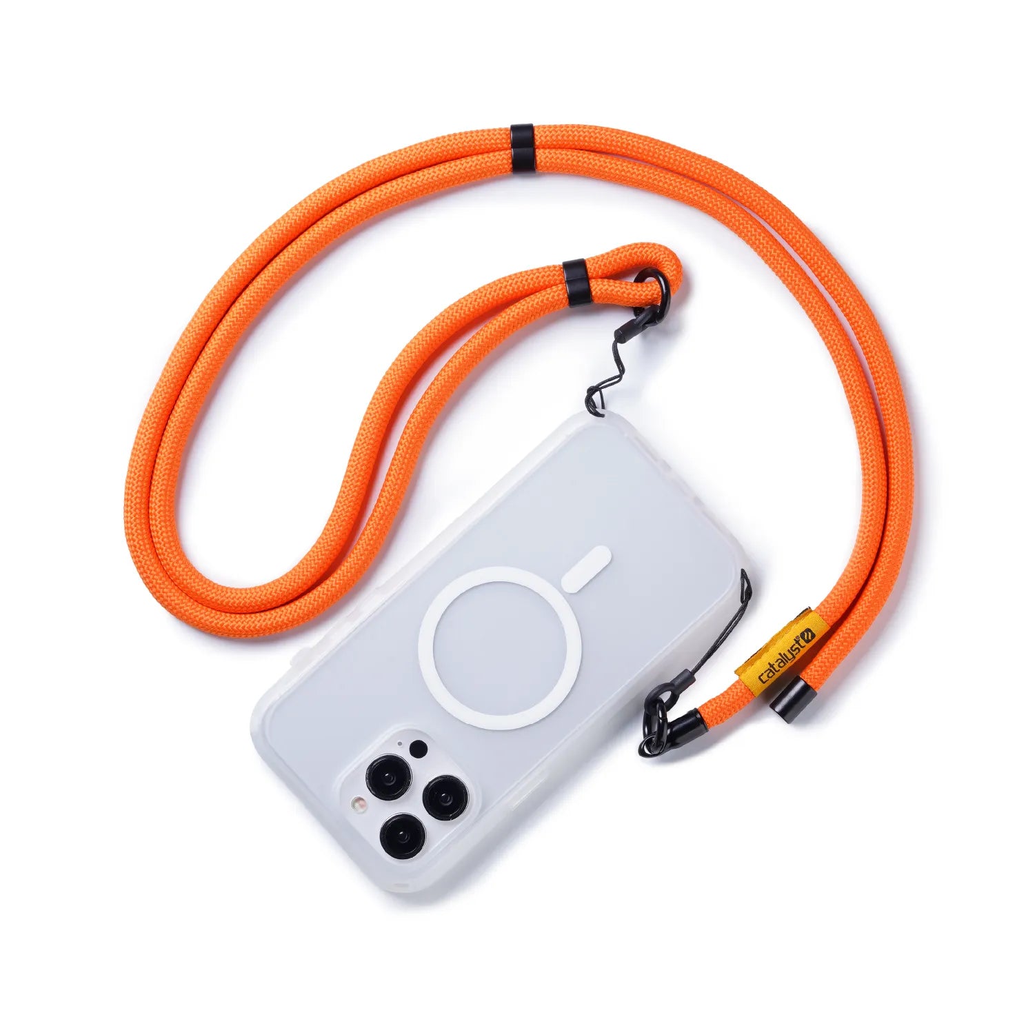 A clear phone case with a circular MagSafe symbol is attached to the orange Catalyst Case US Crossbody Shoulder Strap, featuring a black clasp and yellow "callme" tag, shown on a white background.