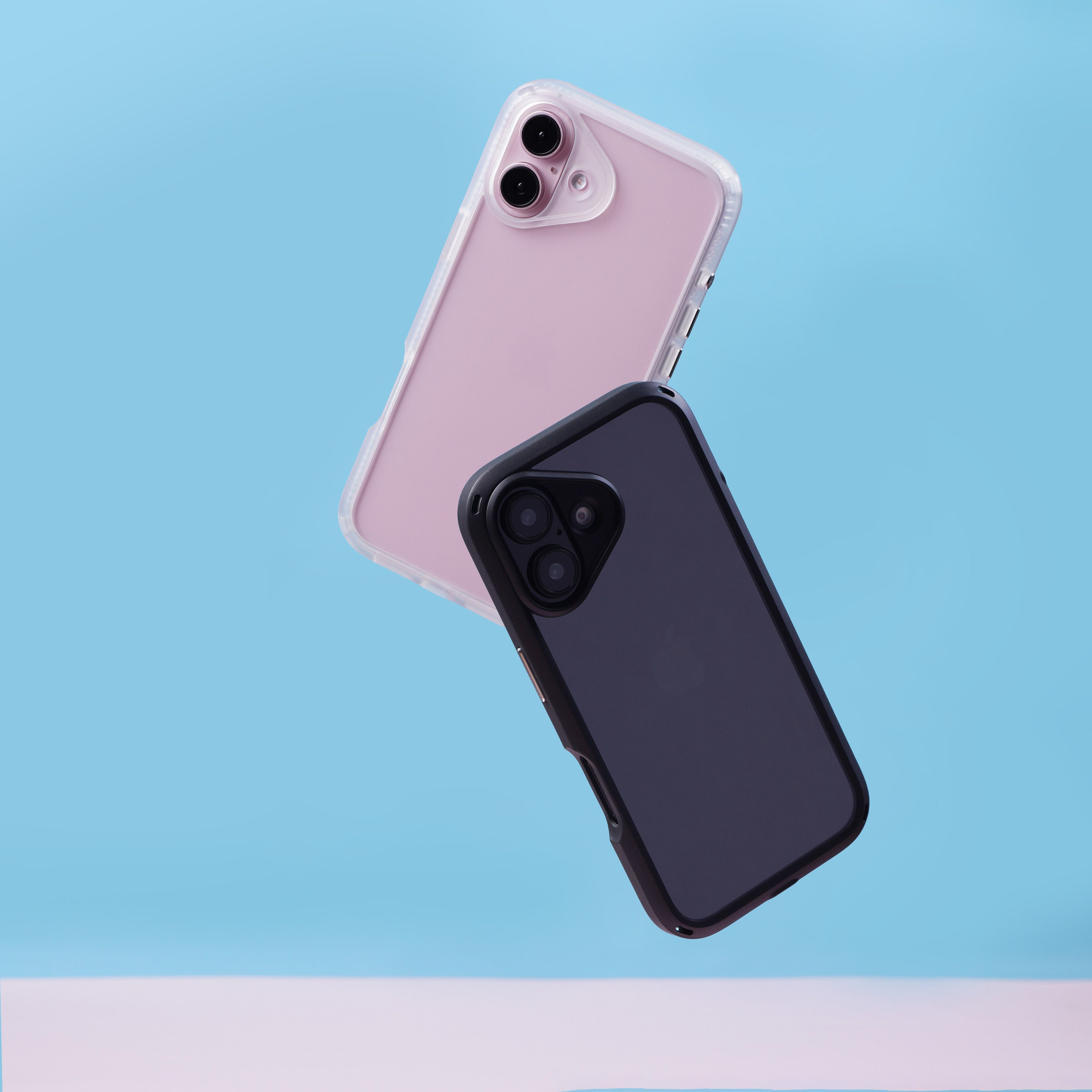 Two smartphones in Catalyst Drop Proof Cases appear to be floating against a blue background; one case is light pink, the other dark gray.