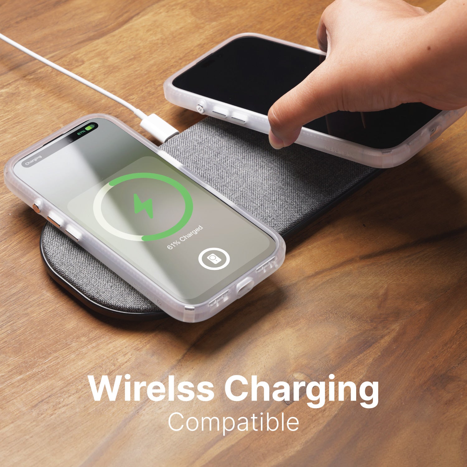 A hand is placing an iPhone equipped with the Catalyst Drop Proof Case onto a wireless charging pad, while another phone with the same Catalyst case is already shown charging on the pad. Text at the bottom reads, "Wireless Charging Compatible.