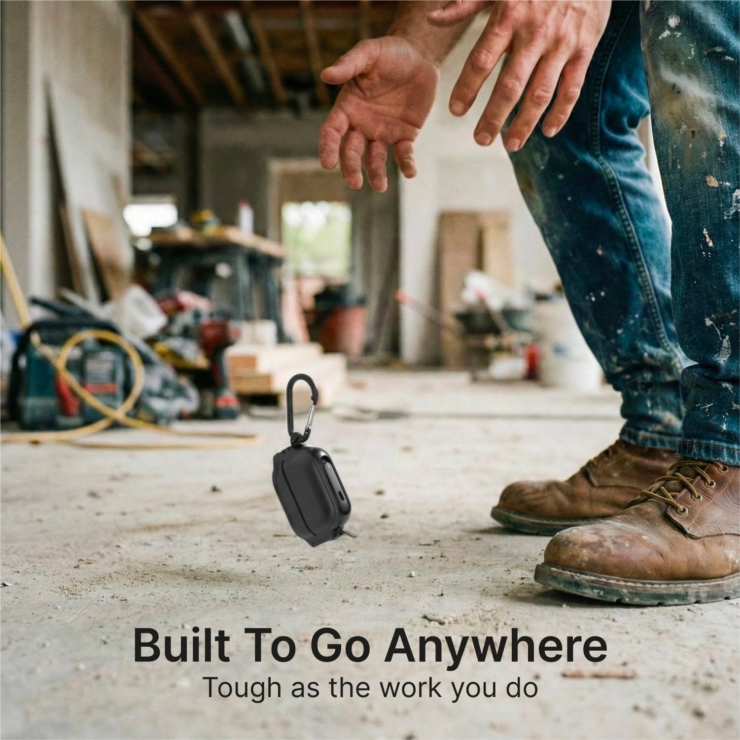 A person in jeans and work boots stands on a dusty construction site. Nearby is the Catalyst Case US AirPods Pro 3—100M Waterproof Total Protection Case with Carabiner, offering rugged, military-grade drop protection. Tools and materials fill the background.