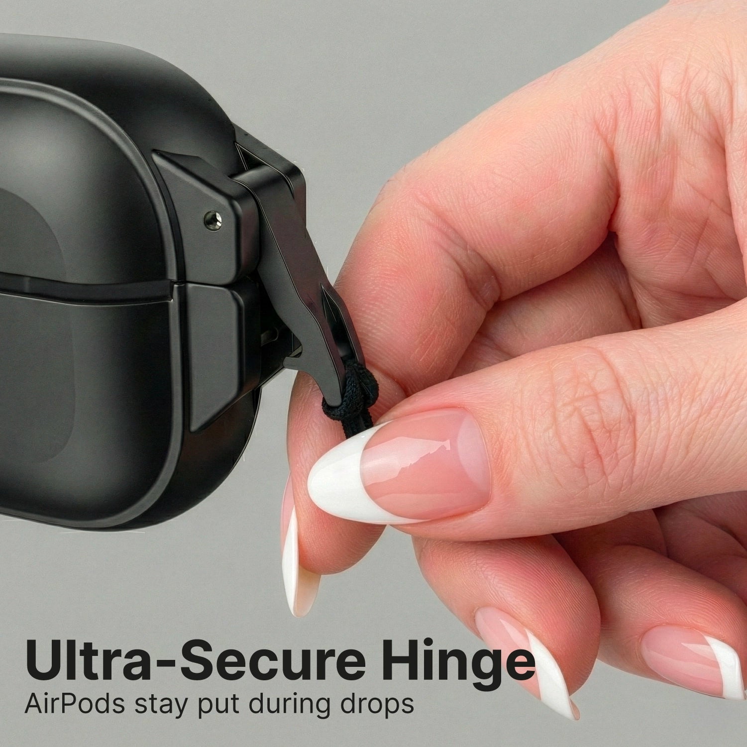 A manicured hand holds the black hinge strap of a Catalyst Case US AirPods Pro 3 - 100M Waterproof Total Protection Case + Carabiner. Bold text: "Ultra-Secure Hinge." Below: "Military-grade drop protection keeps AirPods safe." Plain gray background.