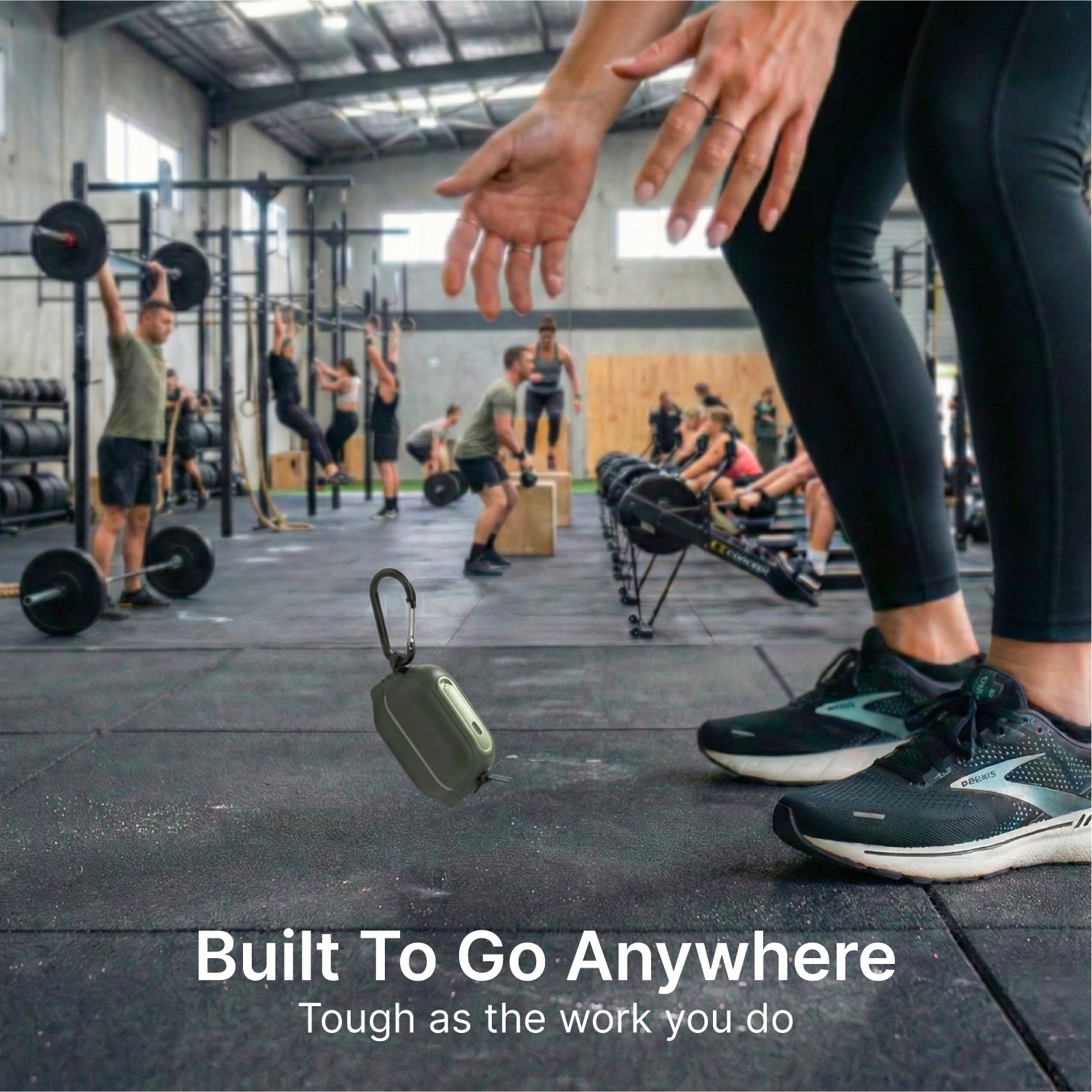 Someone drops the AirPods Pro 3 – 100M Waterproof Total Protection Case + Carabiner by Catalyst Case US on a gym floor. Around them, people lift weights and row. Text: “Military-grade drop protection. Built to go anywhere. Tough as your workout.”.