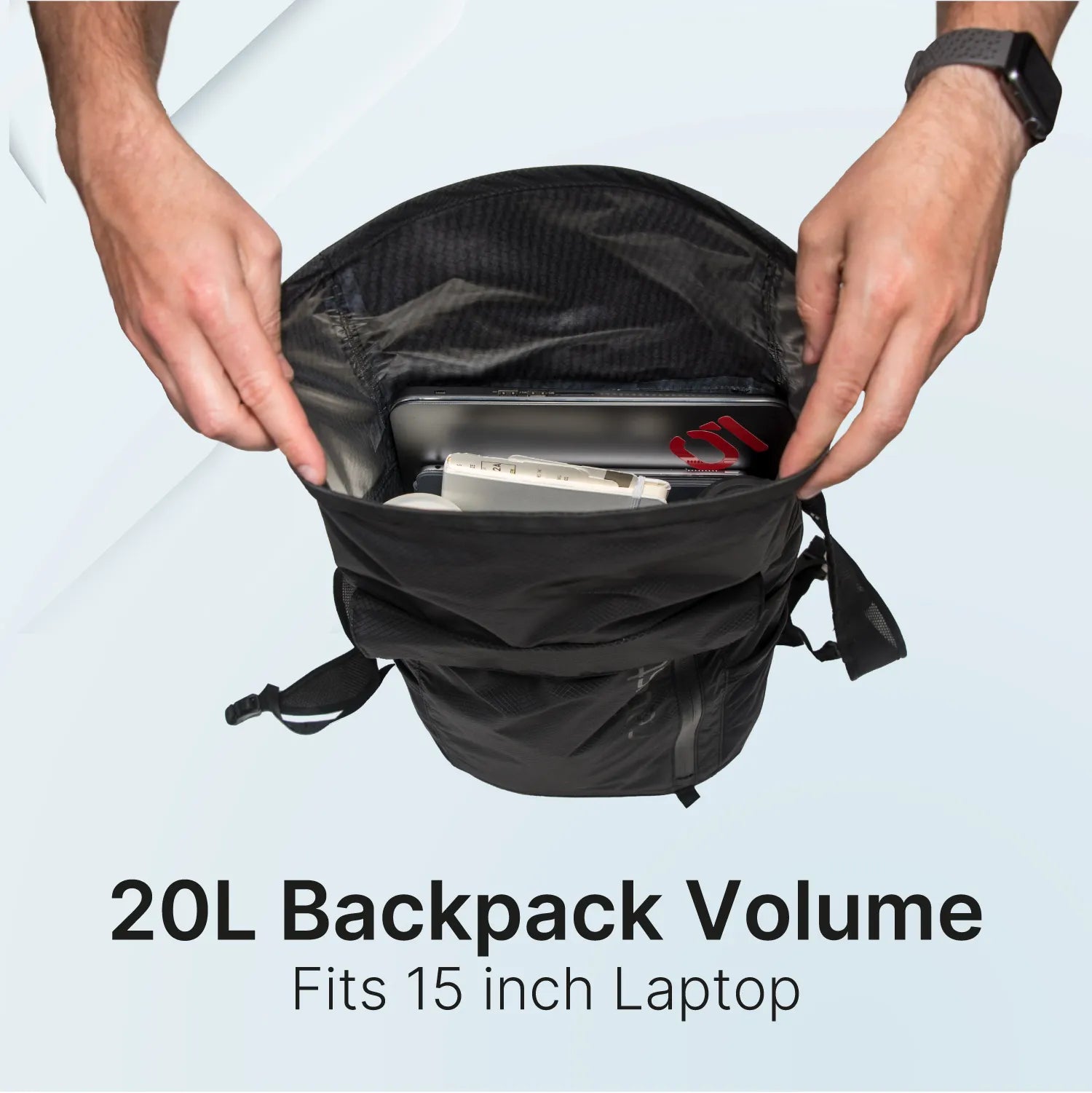 A person’s hands open a Catalyst Case US Waterproof 20L Backpack, revealing a silver laptop and tablet inside. Text reads “20L Backpack Volume” and “Fits 15 inch Laptop.” The person wears a black smartwatch; the background is light gray.
