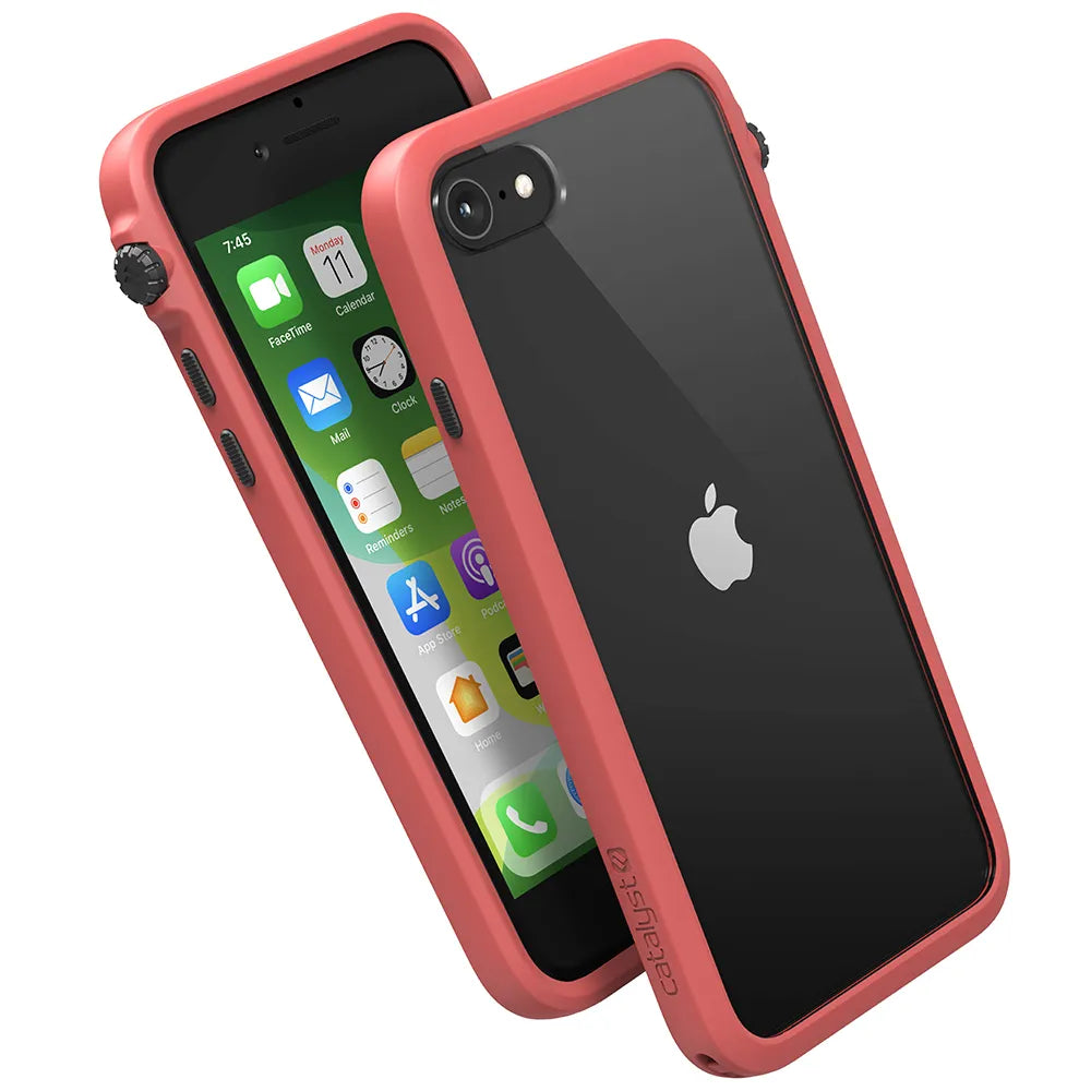 Two iPhone SE (Gen 3/2) devices in black are shown with coral red Catalyst Case US Drop Proof Cases—one displays the home screen, the other shows the Apple logo. The robust case fully frames each phone, featuring visible Catalyst branding on the side.
