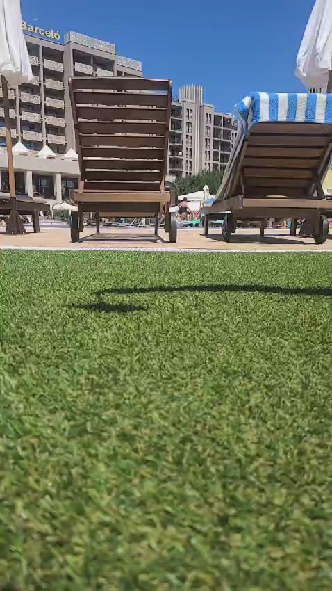 A pink iPhone inside a clear Catalyst drop proof case is dropped onto grass near the pool at the hotel